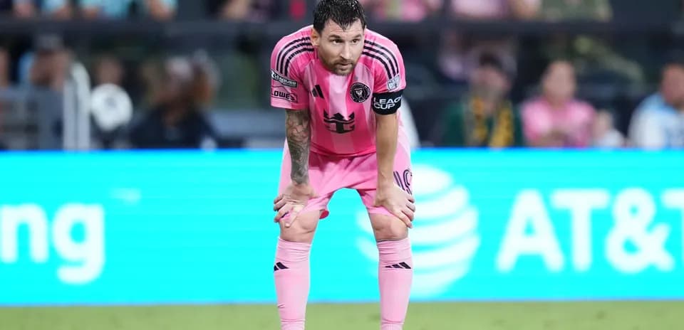 Player in pink jersey bent over on field