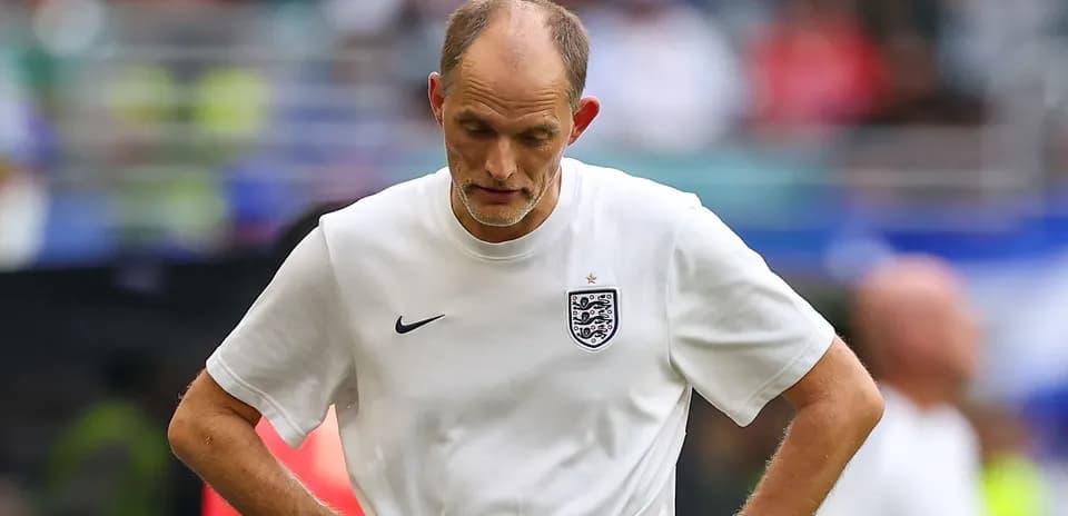 Coach walking on the pitch with downcast expression