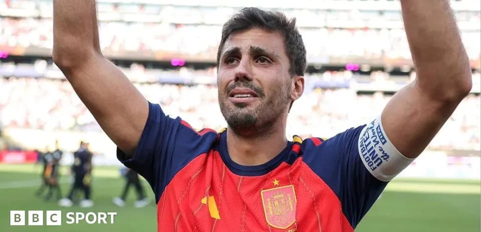 Player celebrating with raised arms in Spain kit