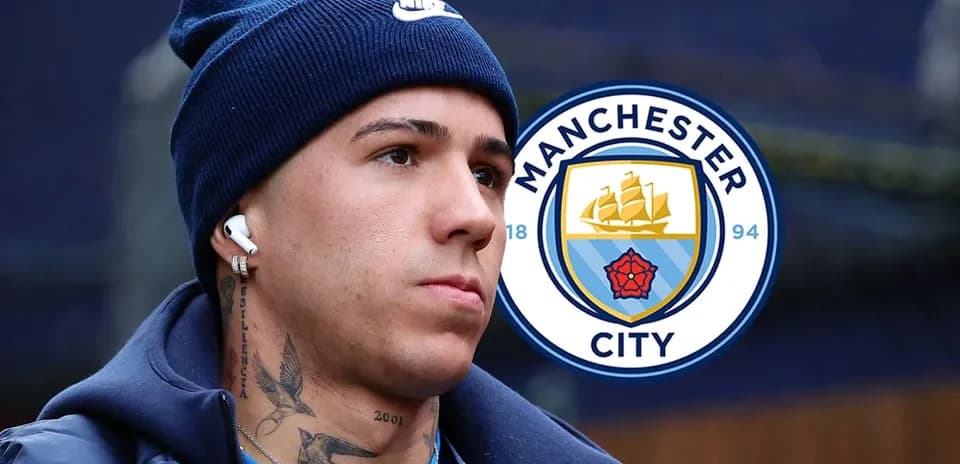 Player wearing headphones near Manchester City logo
