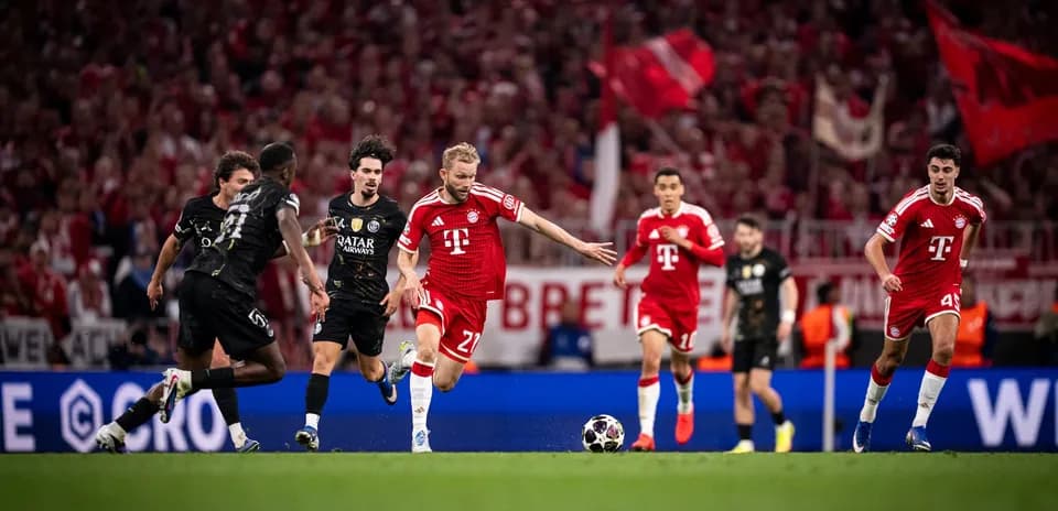 Bayern player dribbling past PSG defenders