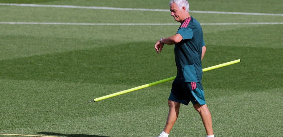 Coach walking with training equipment on the field