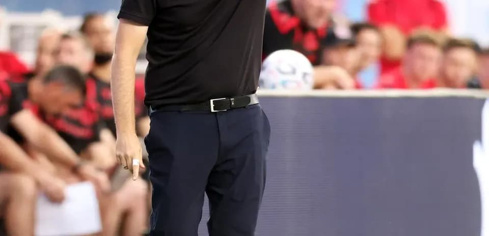 Coach directing players from the sideline during match