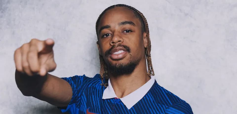 Football player pointing while wearing blue jersey