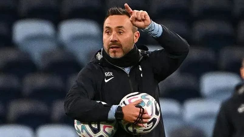 Coach directing players while holding footballs