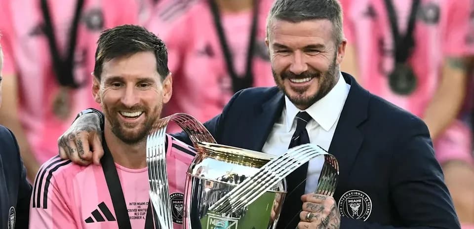Lionel Messi and David Beckham holding trophy together