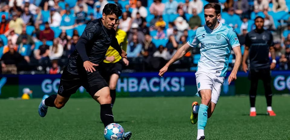 Monterey Bay player dribbling past Loudoun United opponent