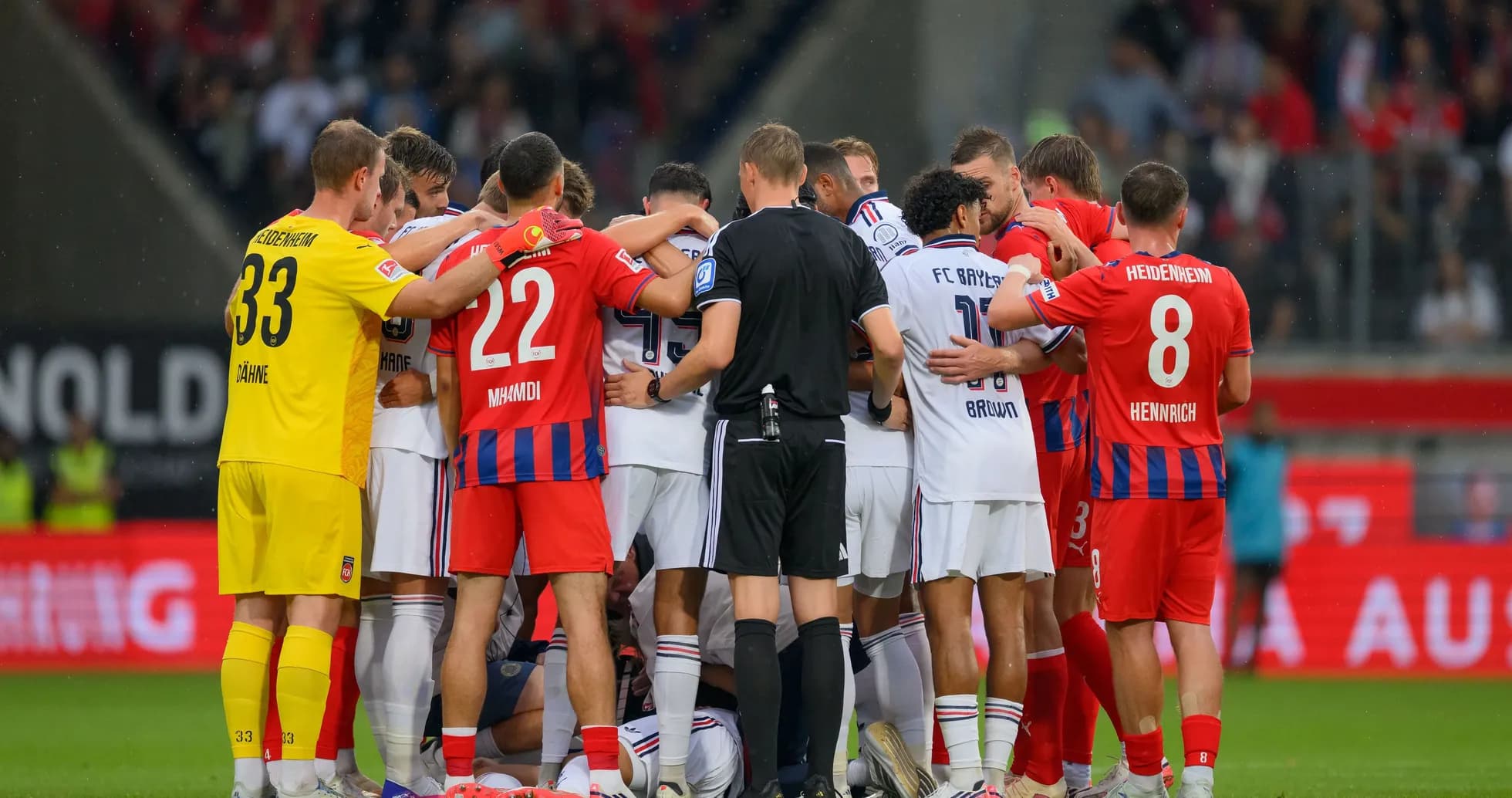 Players from both teams huddled together on pitch