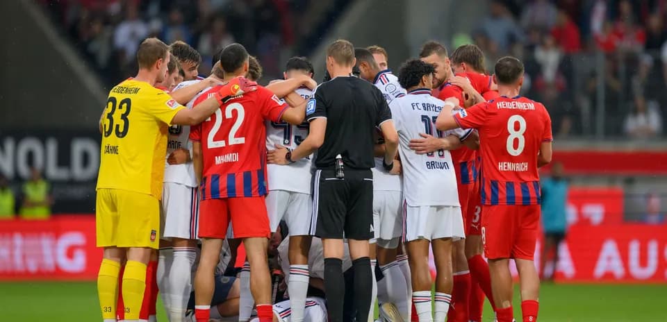 Players from both teams huddled together on pitch