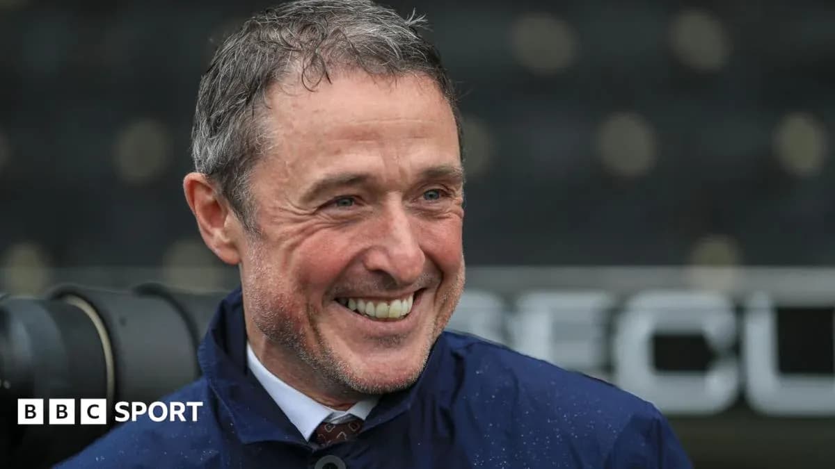 Smiling man in a jacket at a sports venue