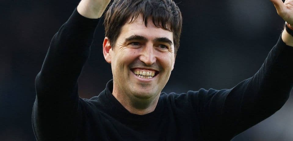 Coach celebrating with raised arms at stadium