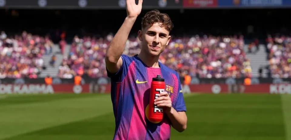 Player waving while holding a water bottle on field