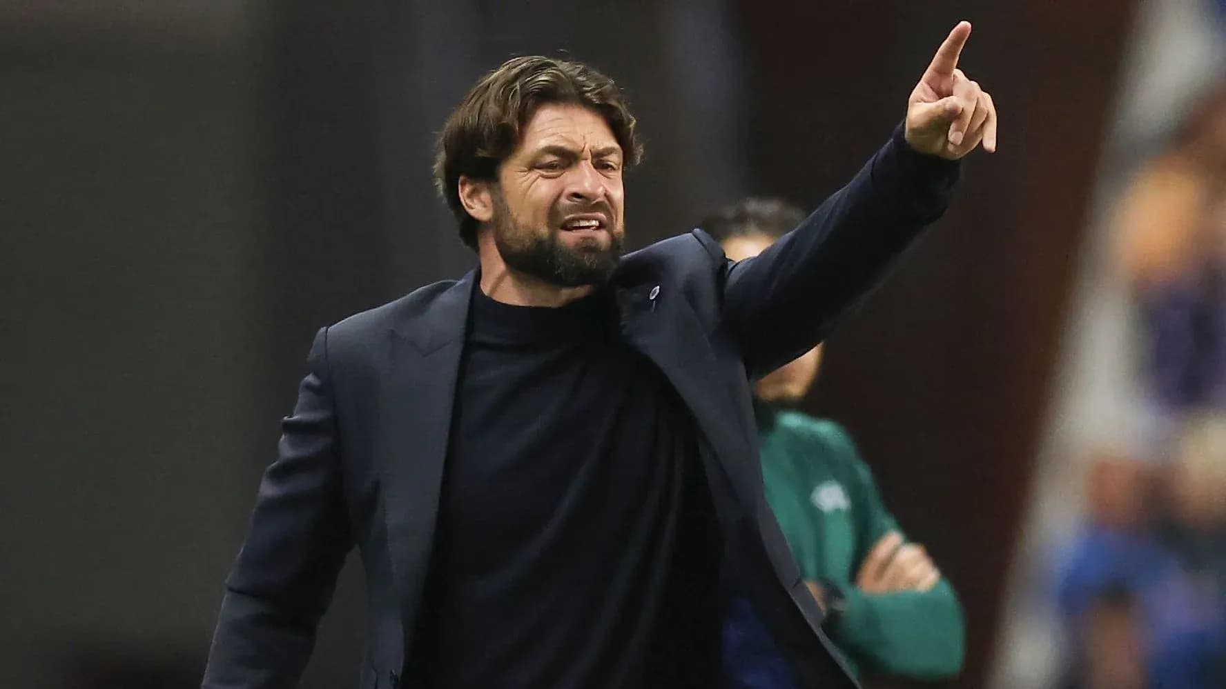 Coach gesturing during a match on the sidelines