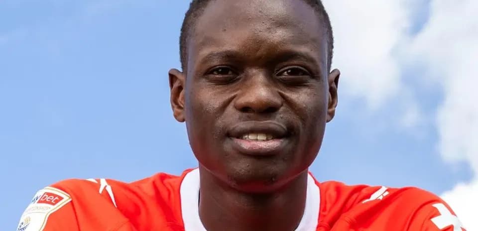 Player wearing red jersey with blue sky background