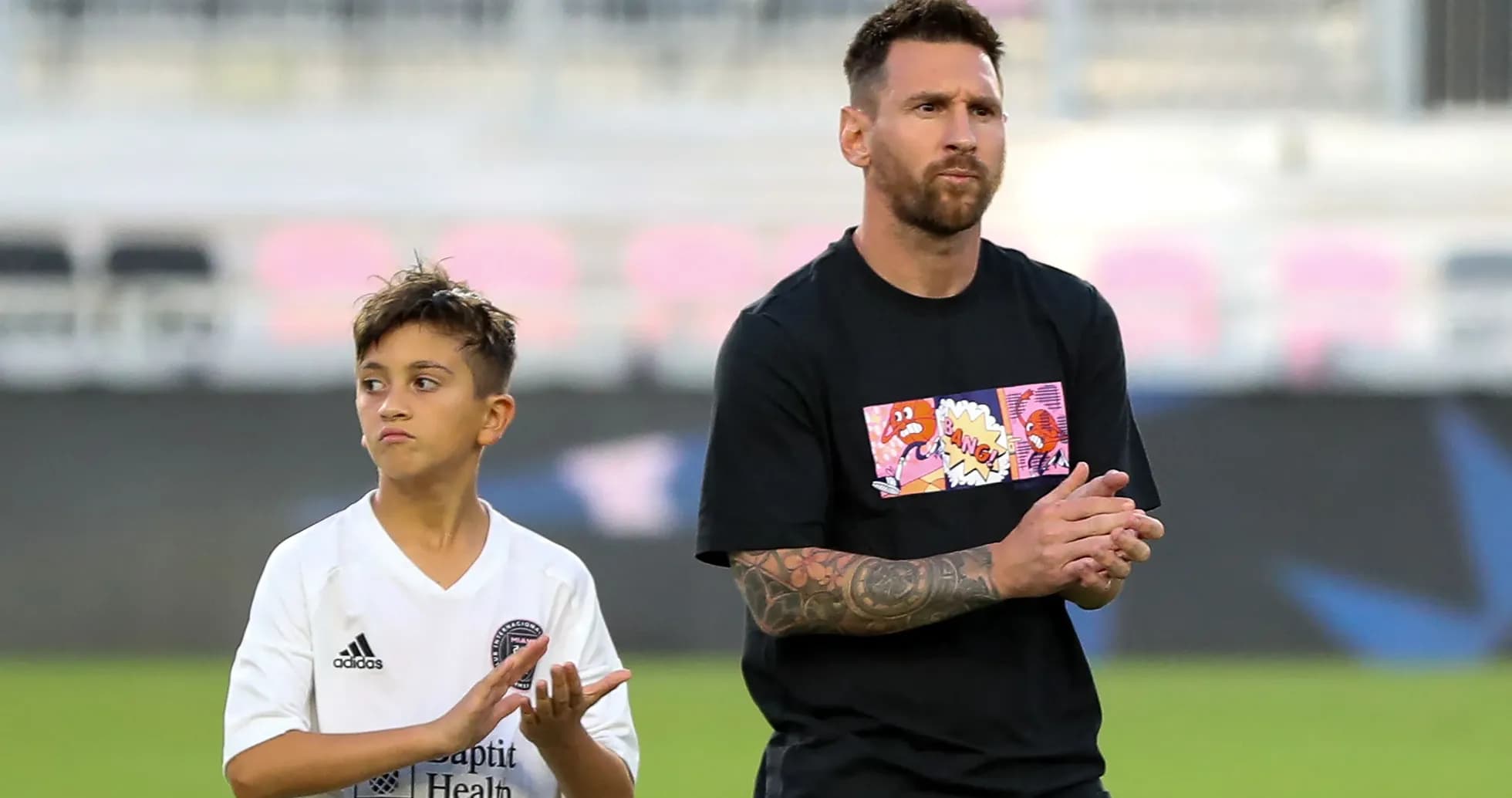 Lionel Messi and a child applauding on field