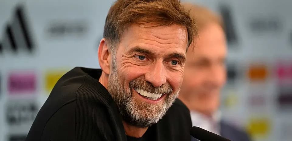 Manager smiling at press conference with microphone