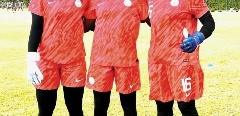 Three female football players in red training kits
