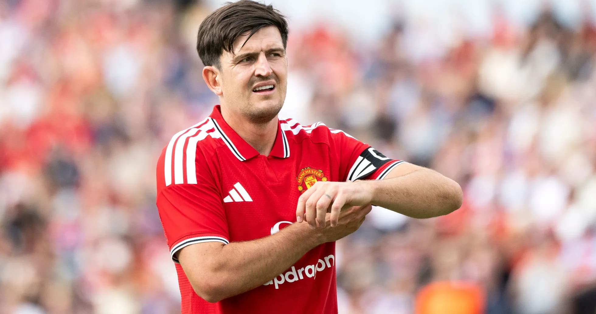 Player adjusting wrist while wearing Manchester United jersey