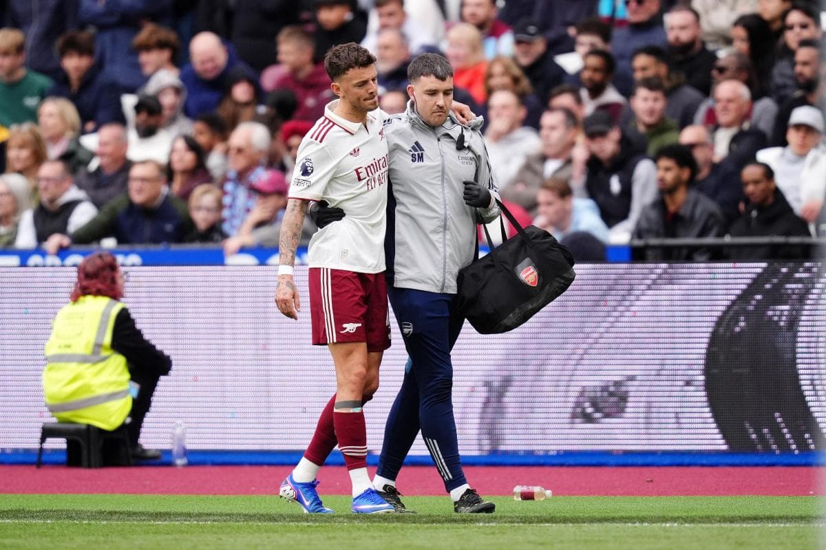 Player receiving assistance from medical staff on pitch