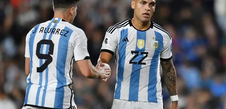 Two Argentina players exchanging a handshake on field