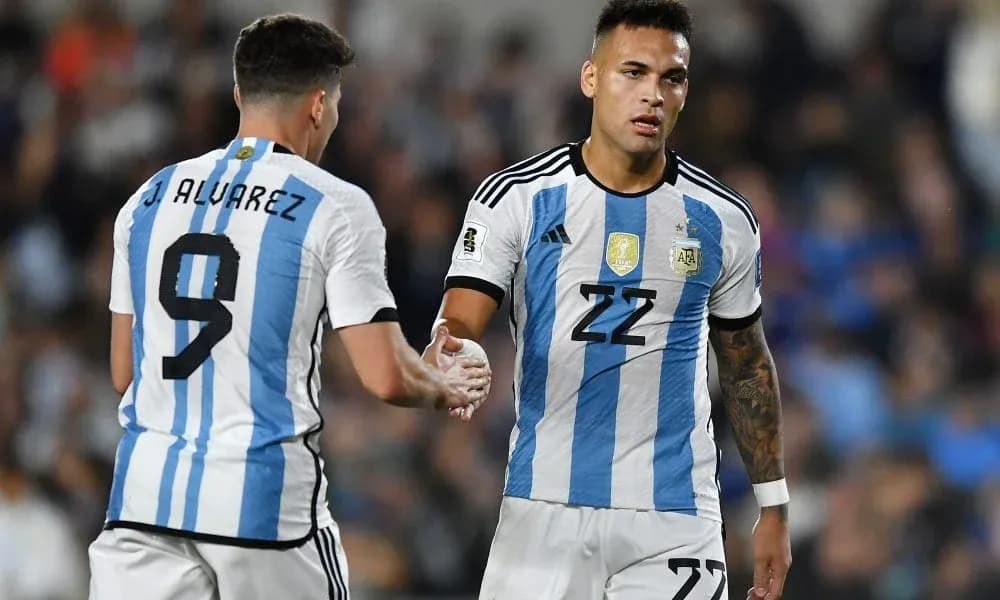 Two Argentina players exchanging a handshake on field