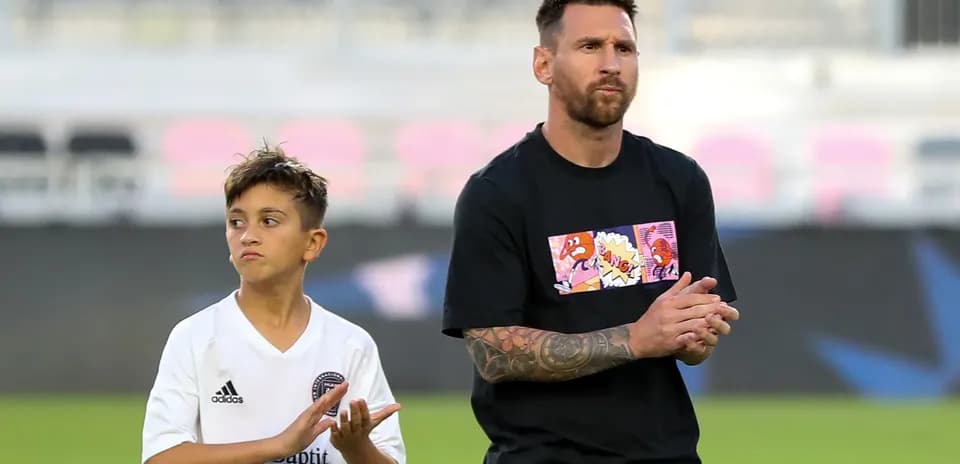 Lionel Messi and a young player applauding together