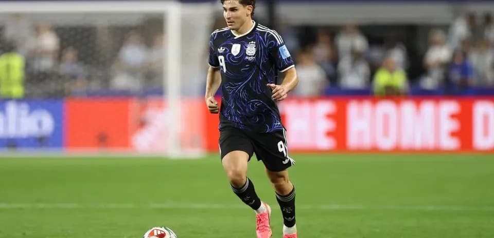 Player in black kit running on football pitch