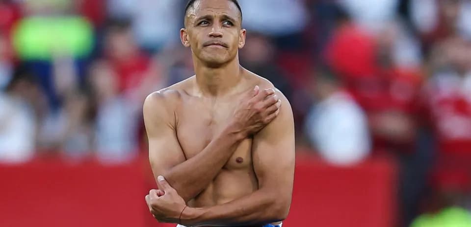 Player with shirt off, holding shoulder on field