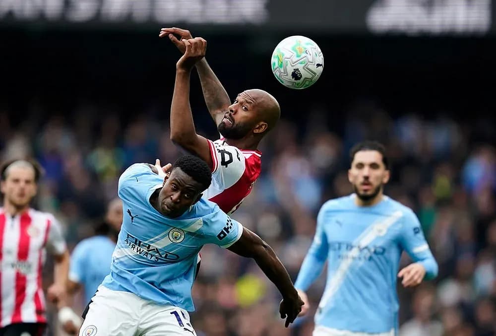 Manchester City player challenges Brentford player for ball