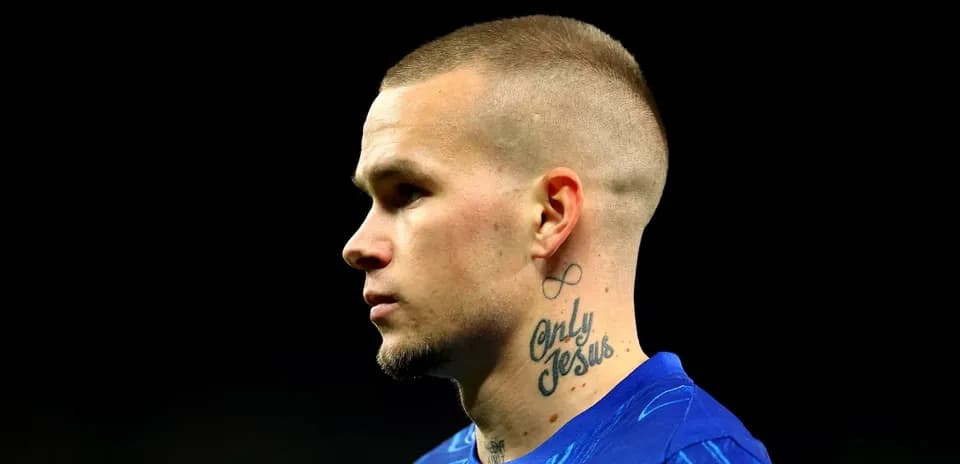Player with tattoos wearing blue jersey in profile