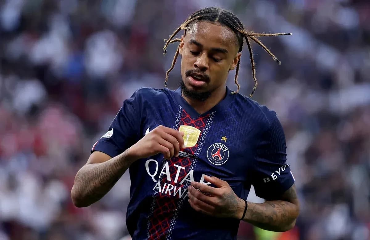 Player inspecting medal after match in PSG jersey