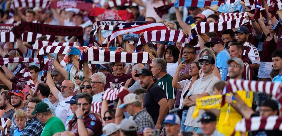 Fans cheering with scarves at football match