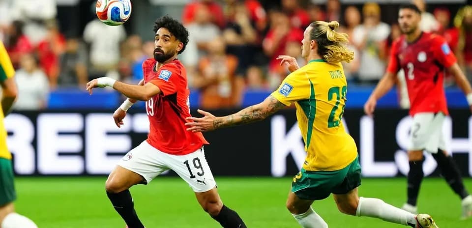 Egyptian player dribbling past Australian opponent during match