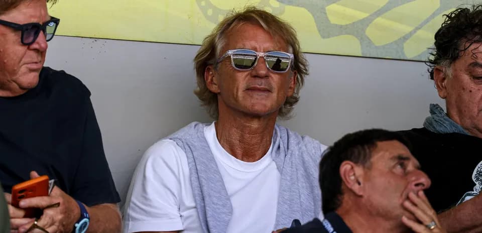Man wearing sunglasses sitting in the stands
