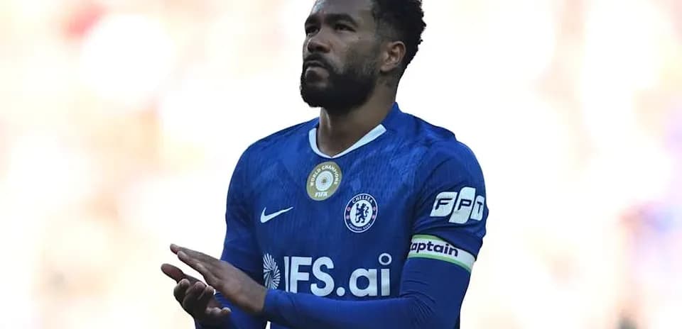 Player in blue jersey applauding fans on field