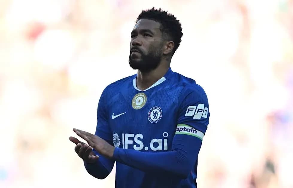 Player in blue jersey applauding fans on field