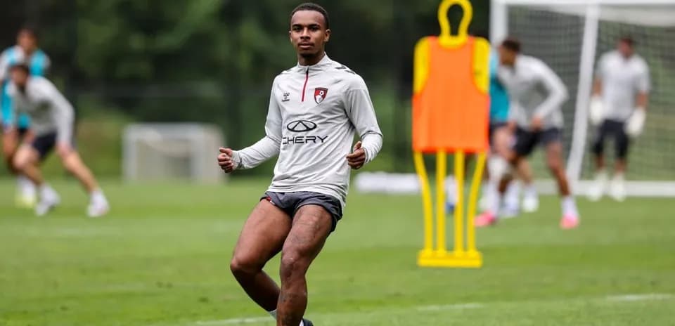 Player training on pitch with teammates in background