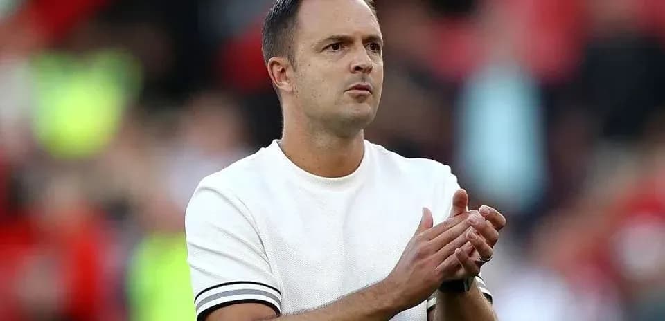 Manager applauding during a match on the sideline