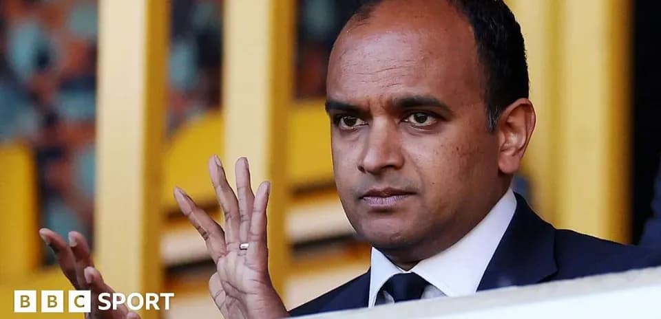 Individual gesturing from a VIP box at a stadium