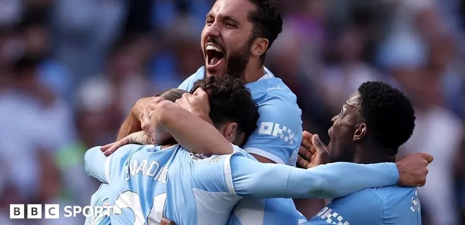 Players celebrating a goal in light blue jerseys