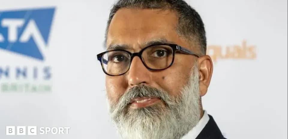Man with glasses and beard at press conference