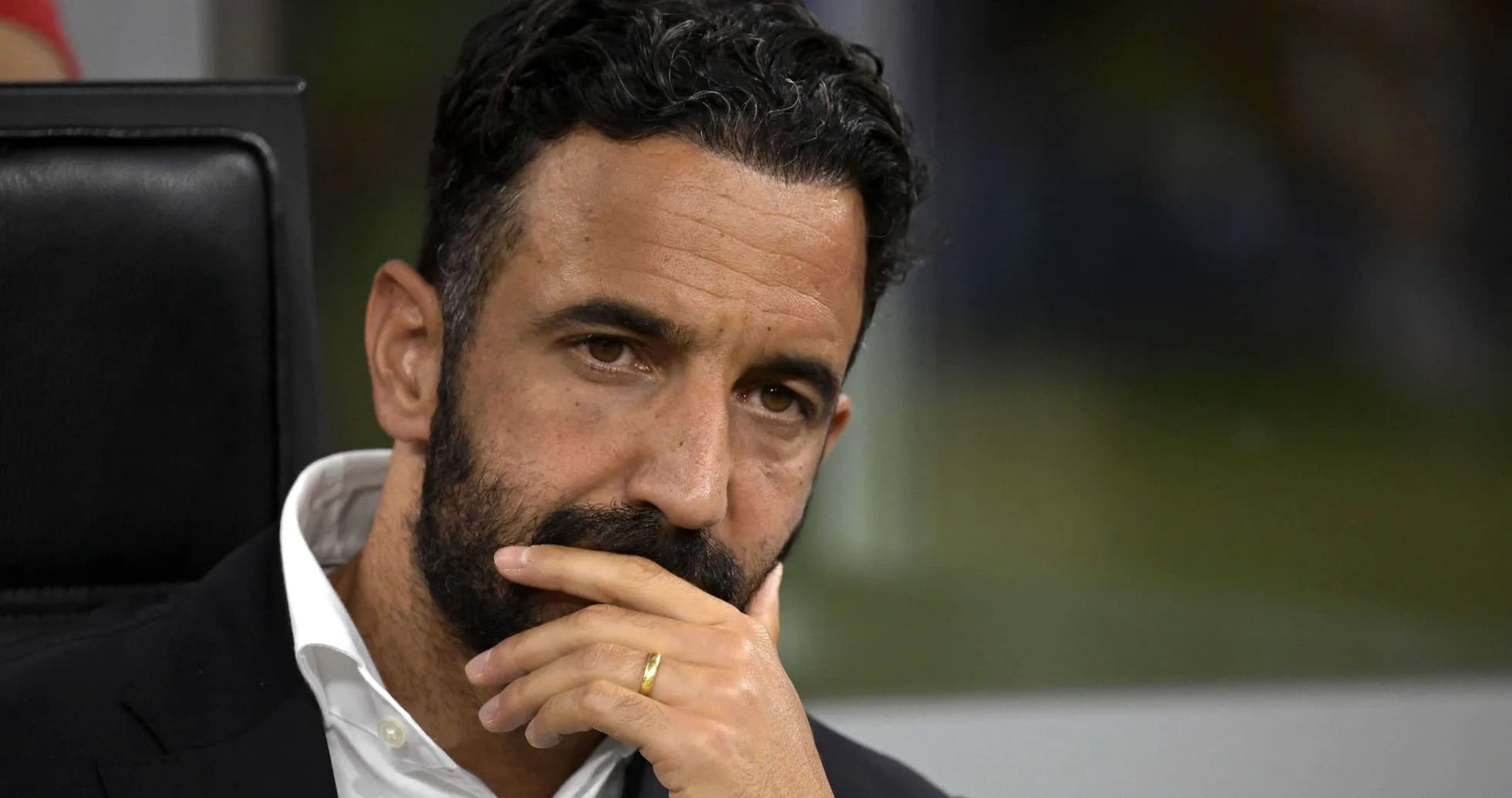 Coach deep in thought during match on bench