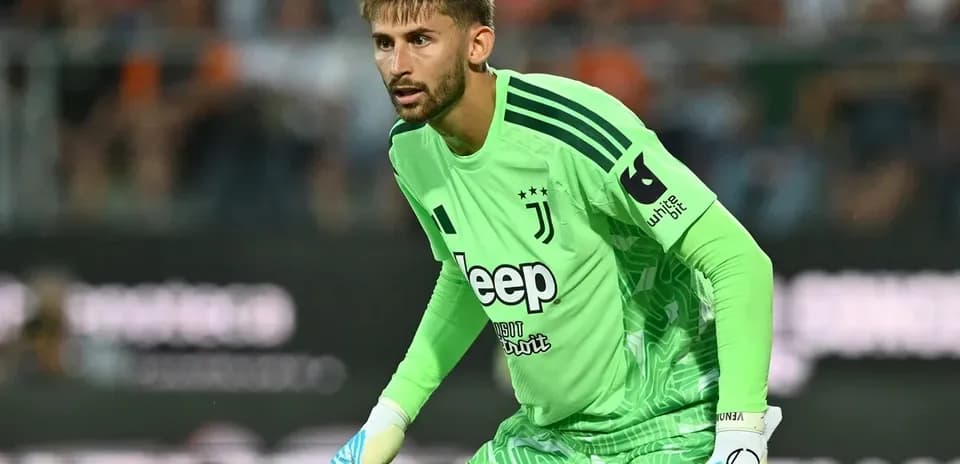 Goalkeeper in green kit preparing for play