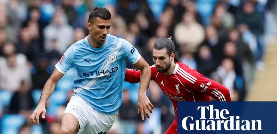 Manchester City player dribbling past Liverpool opponent