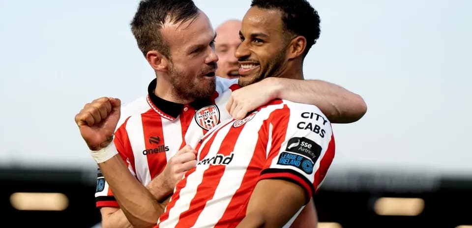 Two players celebrating a goal in team jerseys