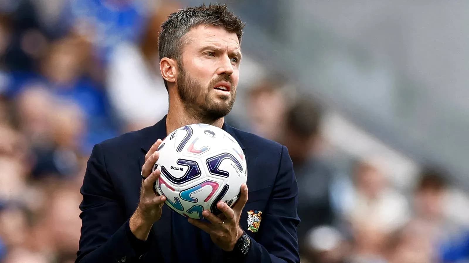 Coach holding a soccer ball during match