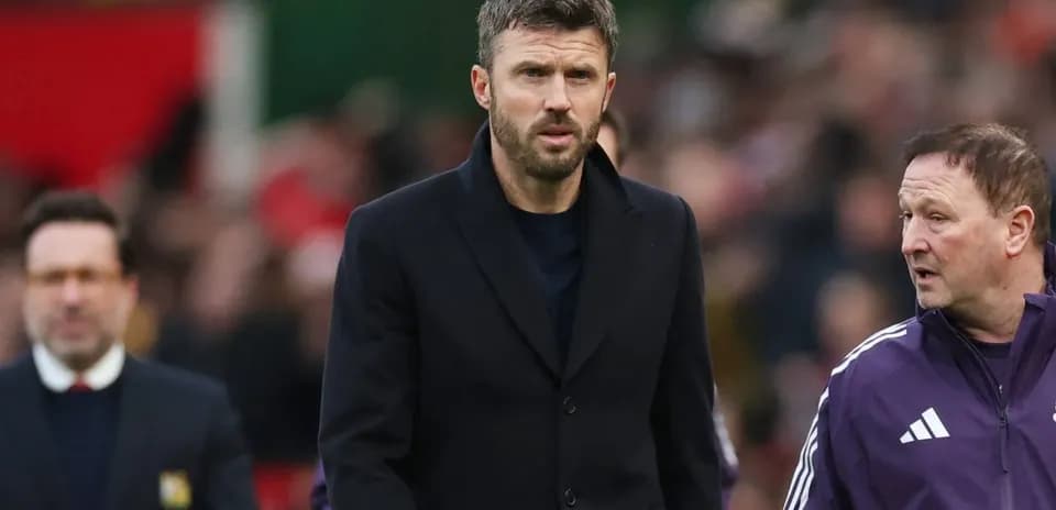 Coach walking on pitch with assistant during match