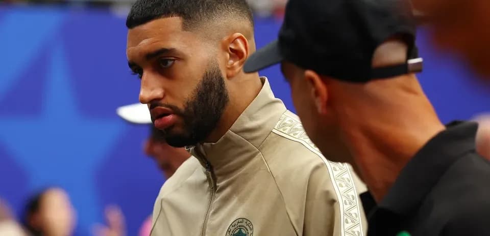 Player in Morocco training kit conversing with teammate