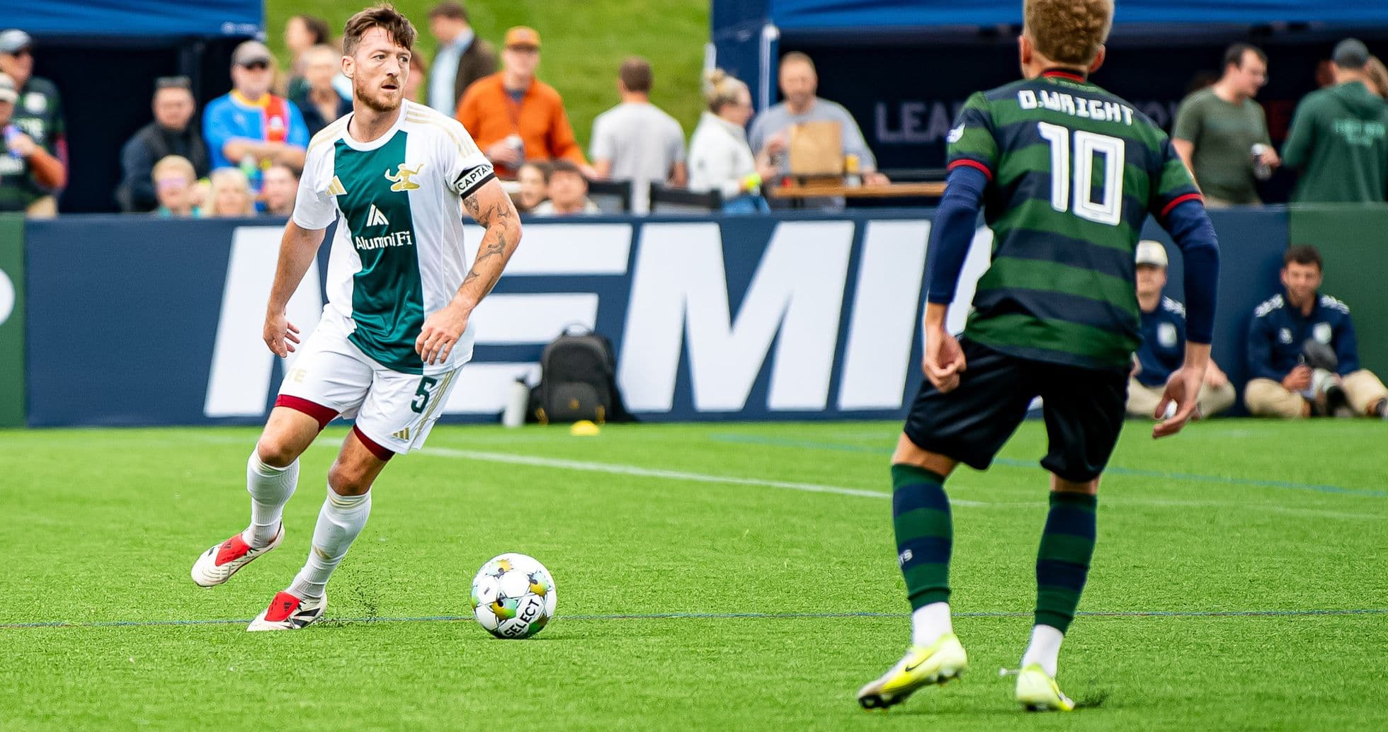 Detroit City player dribbling the ball during match