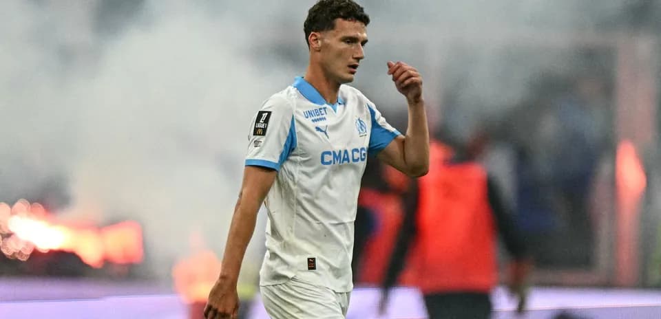 Player walking on pitch during match with smoke